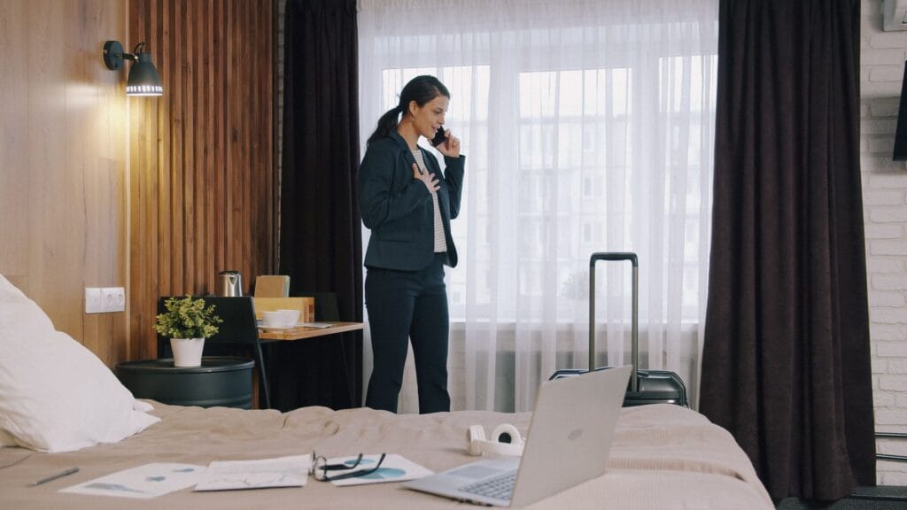 Bizneswoman rozmawia przez telefon w pokoju hotelowym